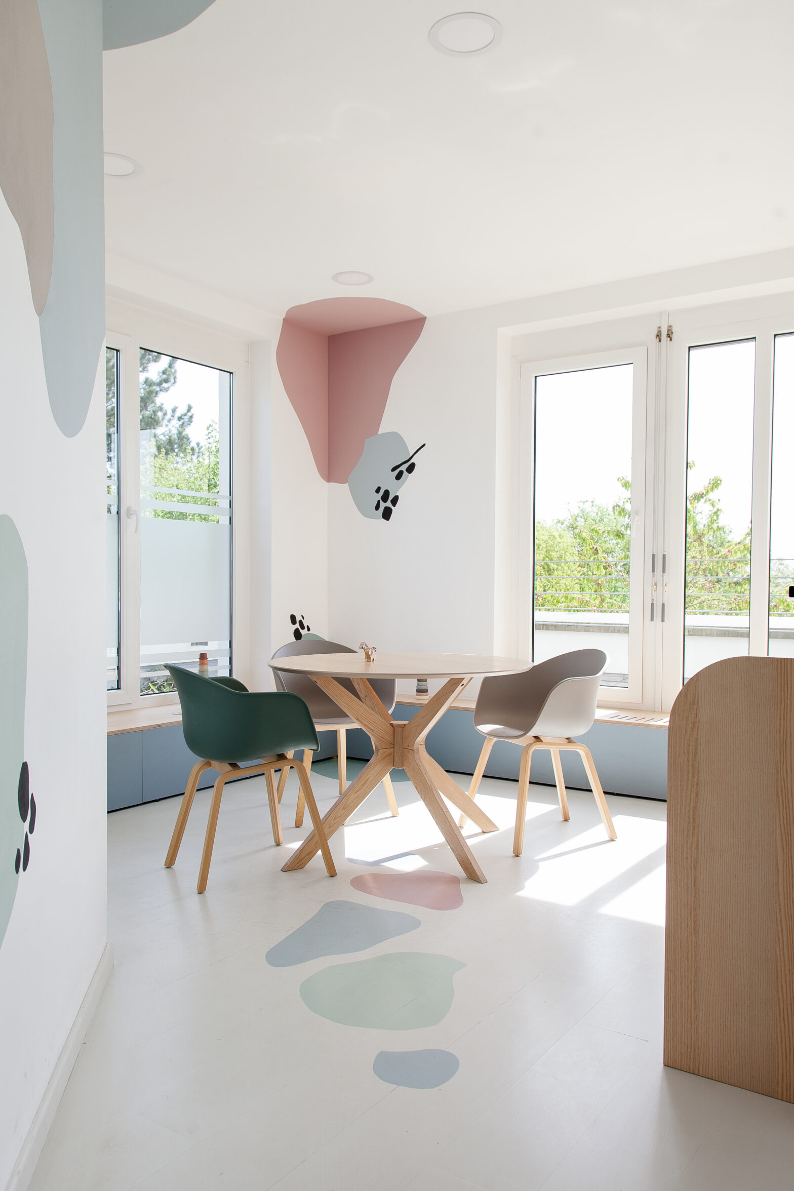 Besprechungsbereich mit rundem Tisch und farbigen Wanddetails
